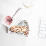 Jogurt i baton granola na biurku jako zdrowa przekąska przy pracy zdalnej