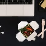 Laptop i smartfon na biurku obok posiłku na wynos do pracy zdalnej