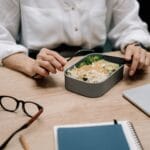 Osoba je zdrowy lunch przy biurku w pracy zdalnej
